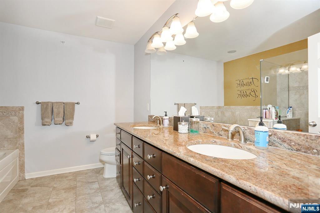 4 Masterson Court, Unit 4 Waldwick, NJ 07463 - Photo 19 of 26 a bathroom with a granite countertop sink a mirror and a shower