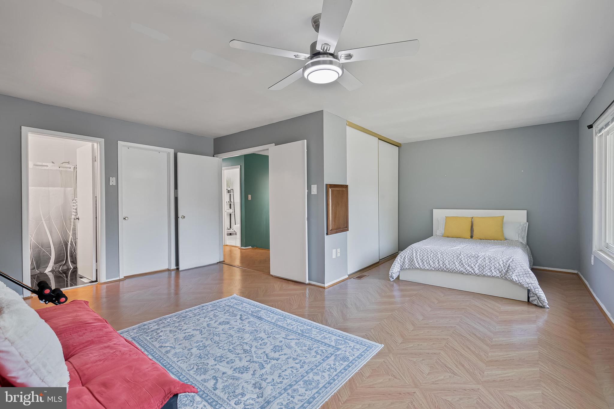 9108 Centerway Road Gaithersburg, MD 20879 - Photo 11 of 33 a spacious bedroom with a large bed and a chandelier