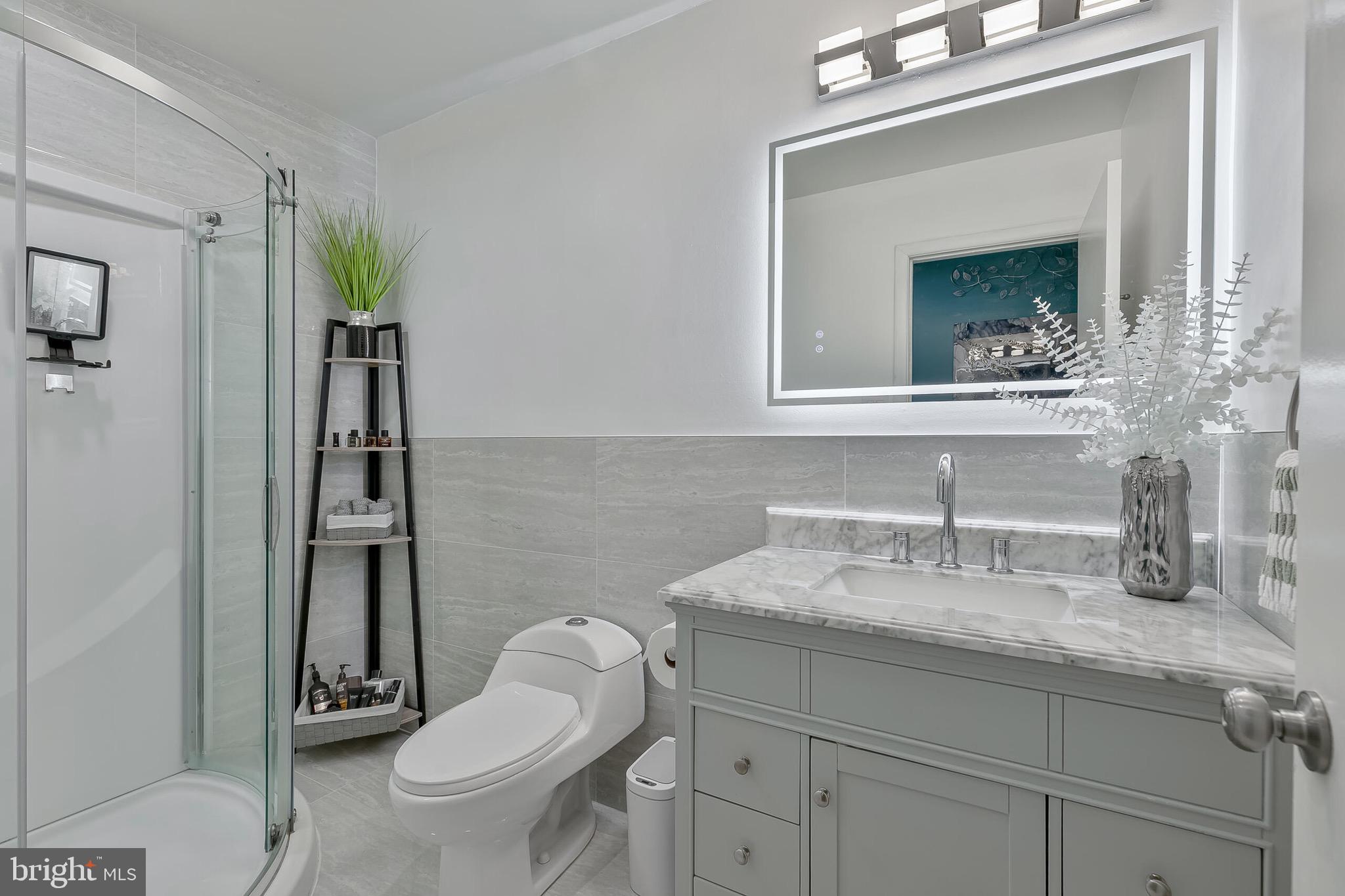 9108 Centerway Road Gaithersburg, MD 20879 - Photo 20 of 33 a bathroom with a granite countertop toilet sink and mirror