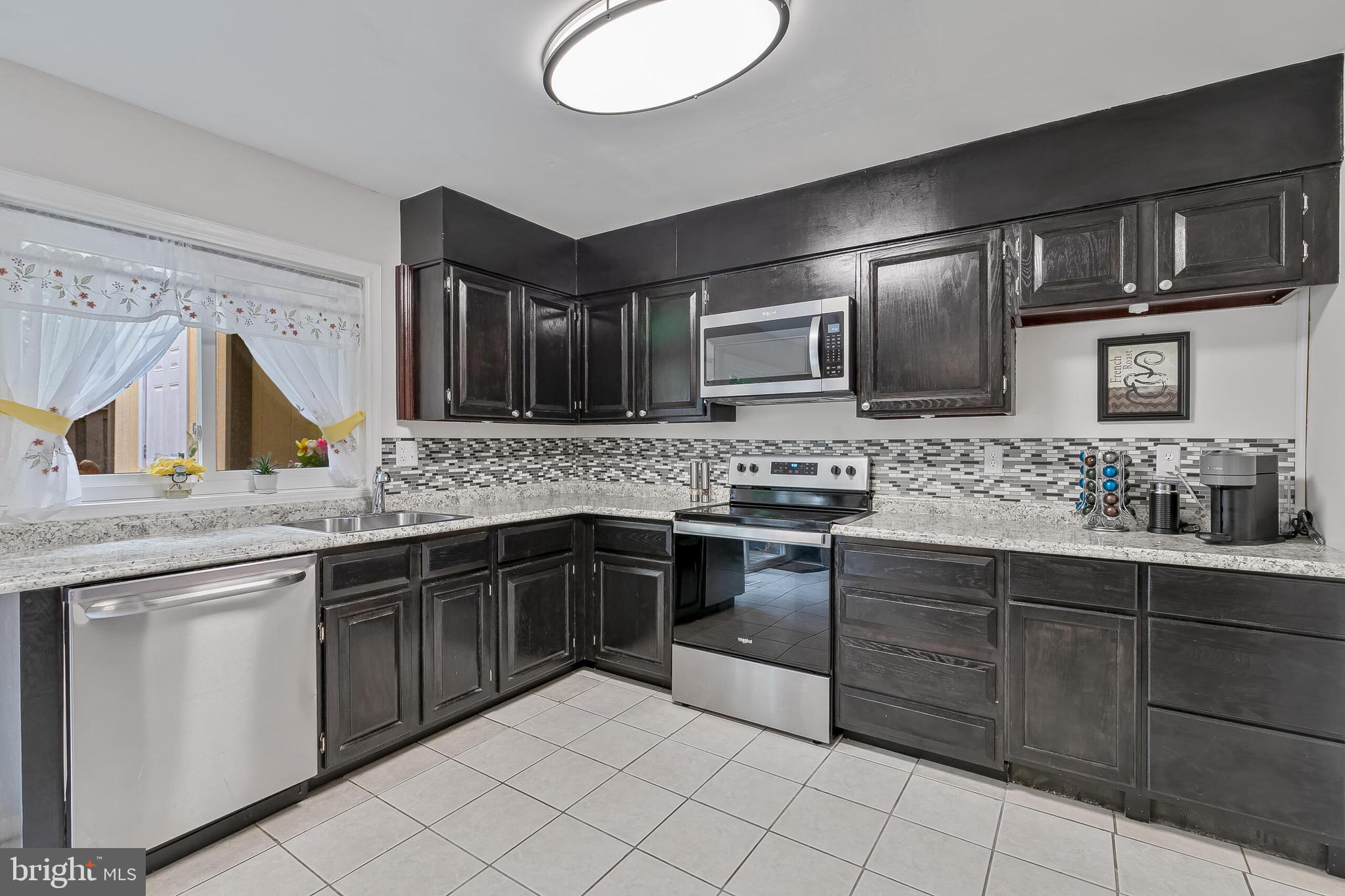9108 Centerway Road Gaithersburg, MD 20879 - Photo 5 of 33 a kitchen with stainless steel appliances granite countertop a sink and stove top oven