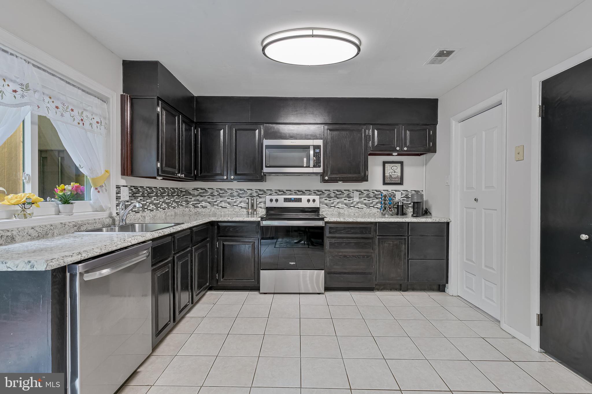 9108 Centerway Road Gaithersburg, MD 20879 - Photo 6 of 33 a kitchen with a sink a stove and cabinets