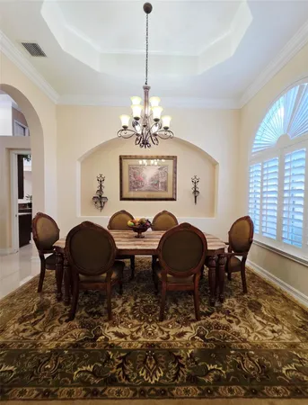 a view of a dining room with furniture a chandelier and window