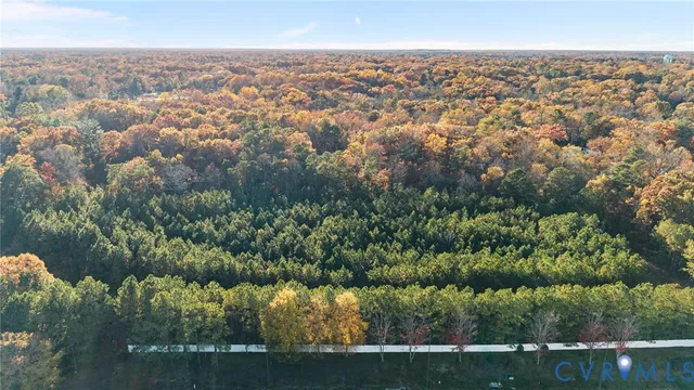 an aerial view of residential houses with outdoor space and trees