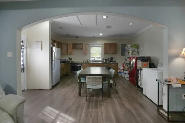 a living room with furniture and a dining table with wooden floor