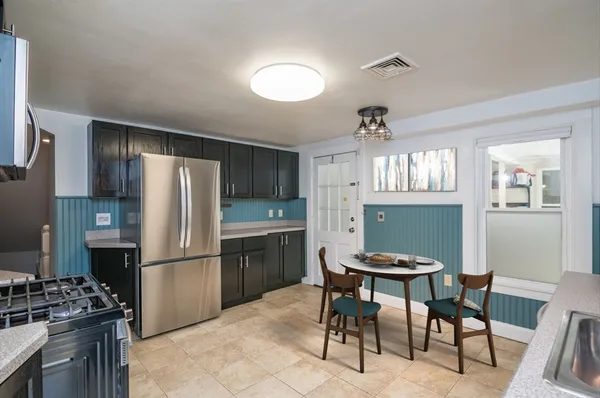 a kitchen with stainless steel appliances kitchen island granite countertop a refrigerator and a stove top oven
