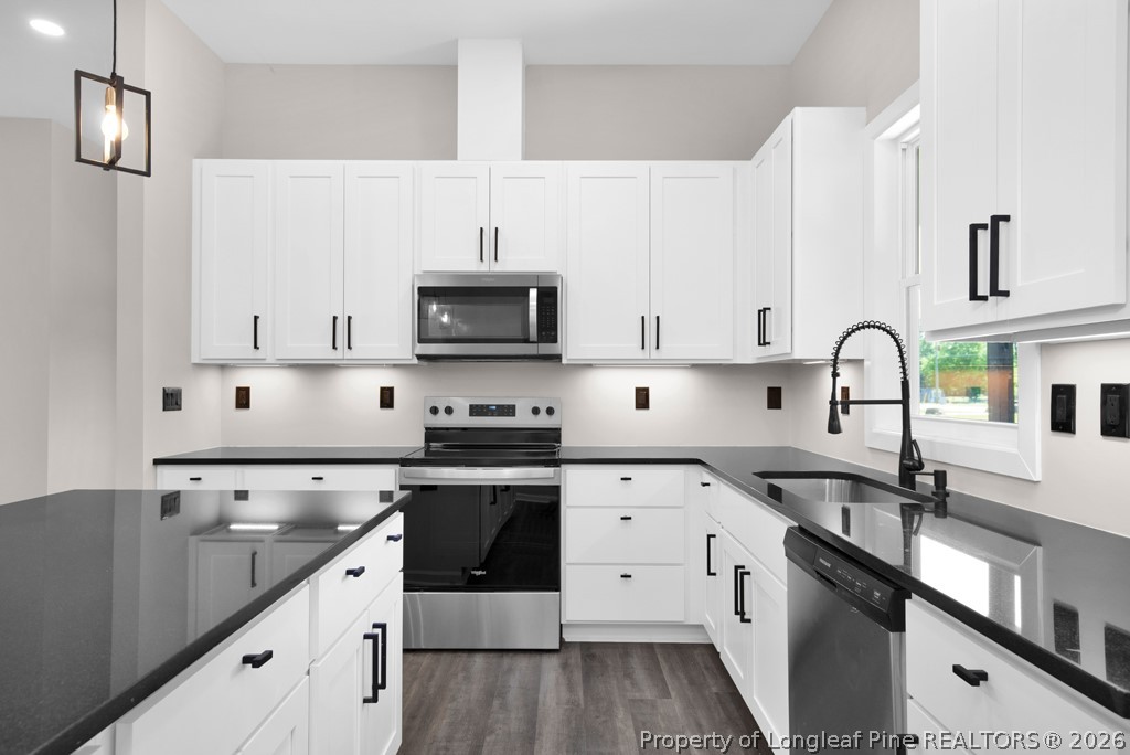 3025 Old Stage Road South Erwin, NC 28339 - Photo 16 of 50 a kitchen with stainless steel appliances white cabinets a sink and a stove