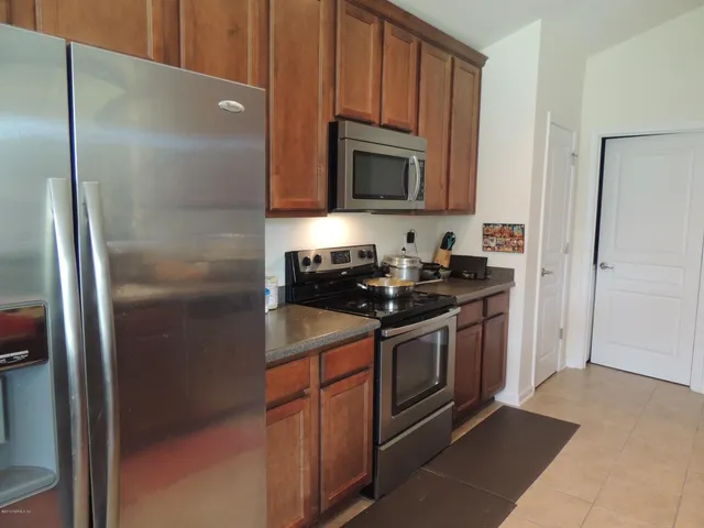 a kitchen with stainless steel appliances granite countertop a refrigerator and a microwave