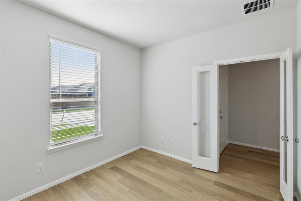 509 River Rdg Drive McKinney, TX 75071 - Photo 27 of 28 an empty room with wooden floor and windows