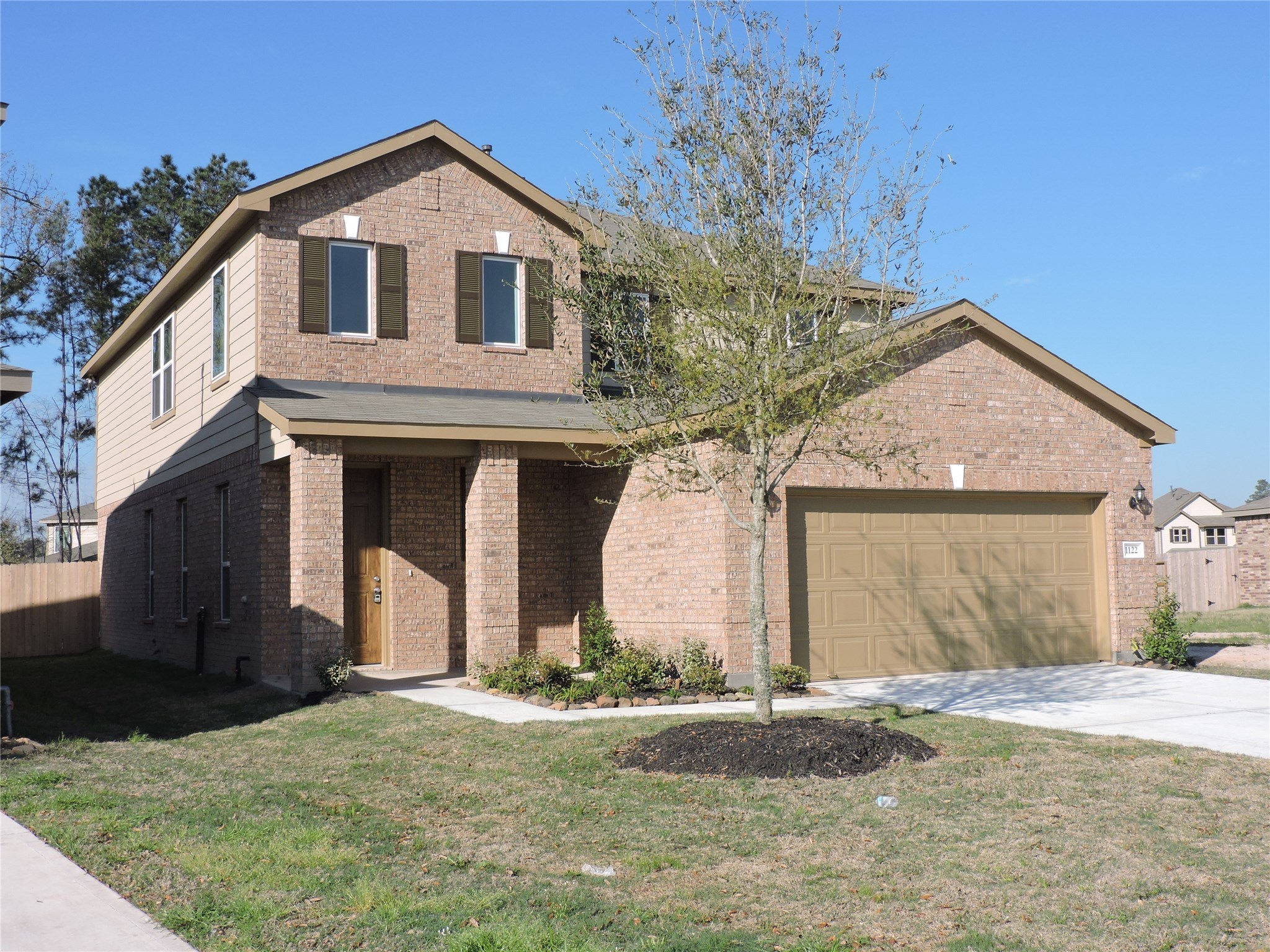 1122 Epworth Ct. Conroe, TX 77304 - Photo 1 of 35 a front view of a house with a yard and garage