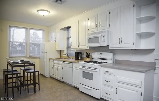a kitchen with white cabinets and white appliances