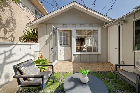 a front view of a house with a chairs and table in a patio