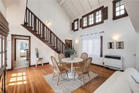 a dining room with furniture entryway and wooden floor