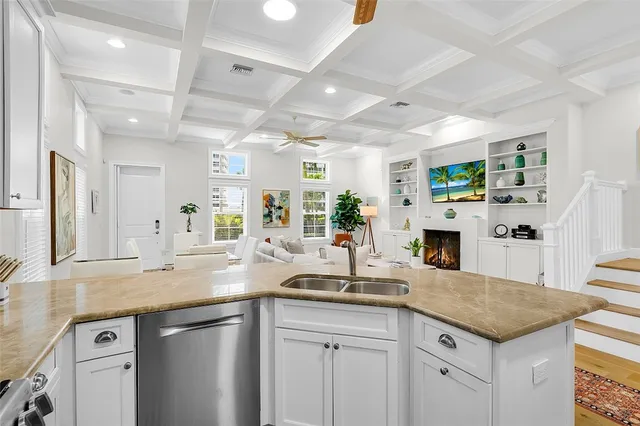 a kitchen with granite countertop a sink and white cabinets with wooden floor