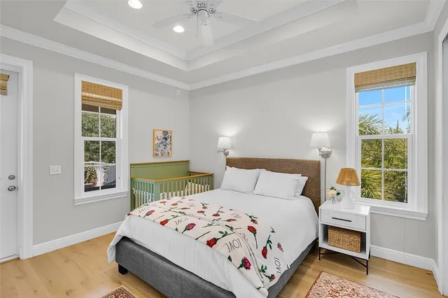 a bedroom with a bed a window and potted plant on the dresser