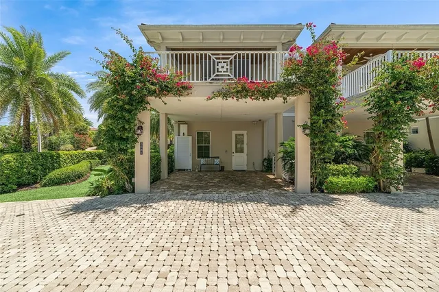 a view of a house with a yard and potted plants