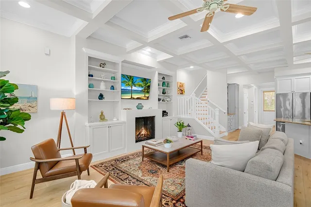 a living room with furniture a fireplace and a chandelier