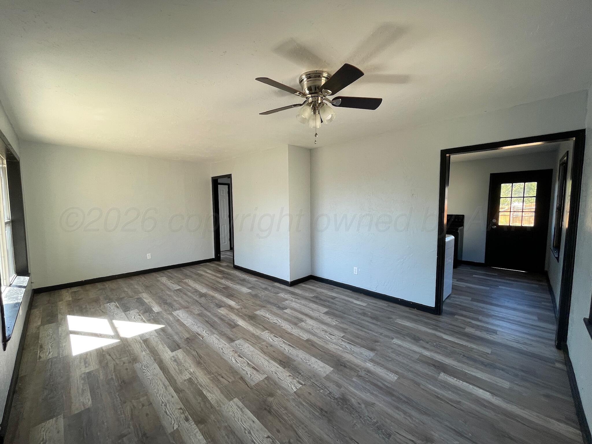 4630 South Ong Street Amarillo, TX 79110 - Photo 2 of 7 a view of empty room with wooden floor and fan