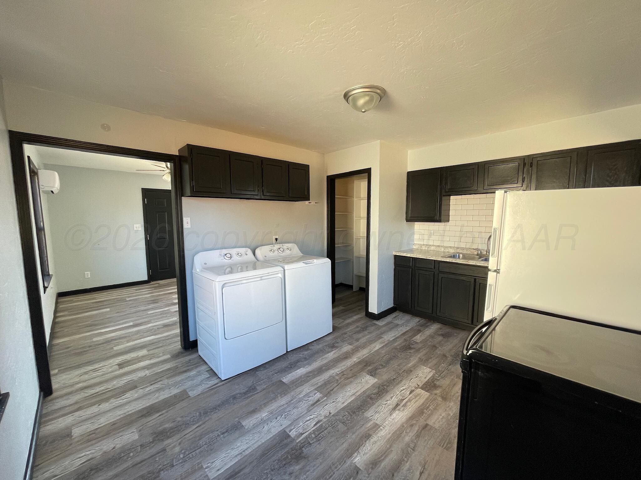4630 South Ong Street Amarillo, TX 79110 - Photo 4 of 7 a view of washer and dryer with wooden floor