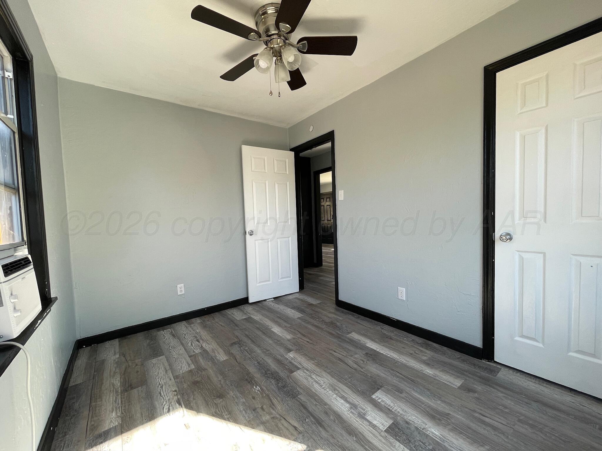 4630 South Ong Street Amarillo, TX 79110 - Photo 5 of 7 a view of an empty room with wooden floor and a window