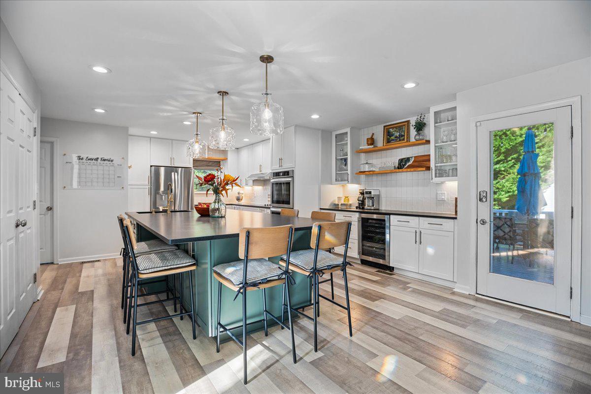 1755 Lottie Fowler Road Prince Frederick, MD 20678 - Photo 11 of 76 a kitchen with a dining table chairs wooden floor and appliances