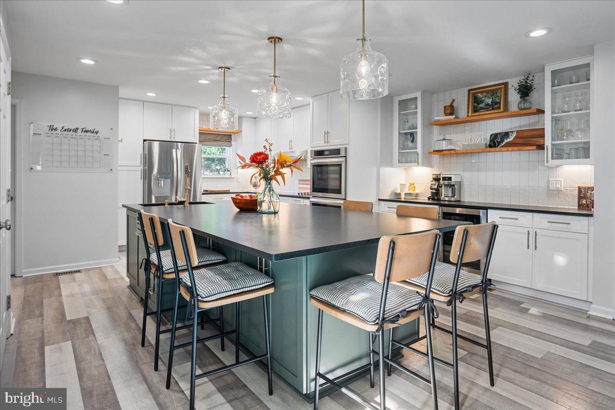 1755 Lottie Fowler Road Prince Frederick, MD 20678 - Photo 12 of 76 a view of a dining room and livingroom with furniture wooden floor a rug a chandelier