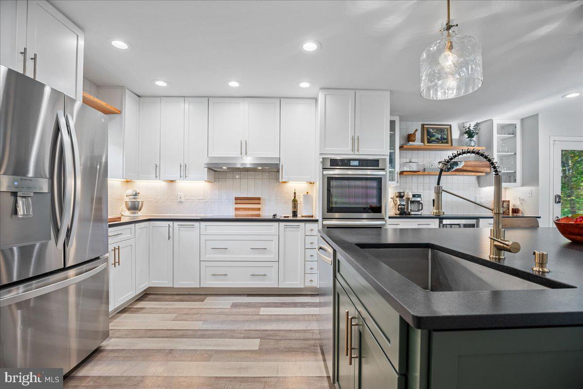 1755 Lottie Fowler Road Prince Frederick, MD 20678 - Photo 18 of 76 a kitchen with a sink stainless steel appliances and white cabinets