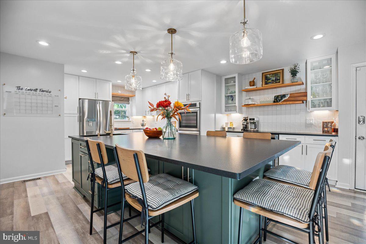1755 Lottie Fowler Road Prince Frederick, MD 20678 - Photo 19 of 76 a room with stainless steel appliances kitchen island granite countertop a dining table chairs and a refrigerator