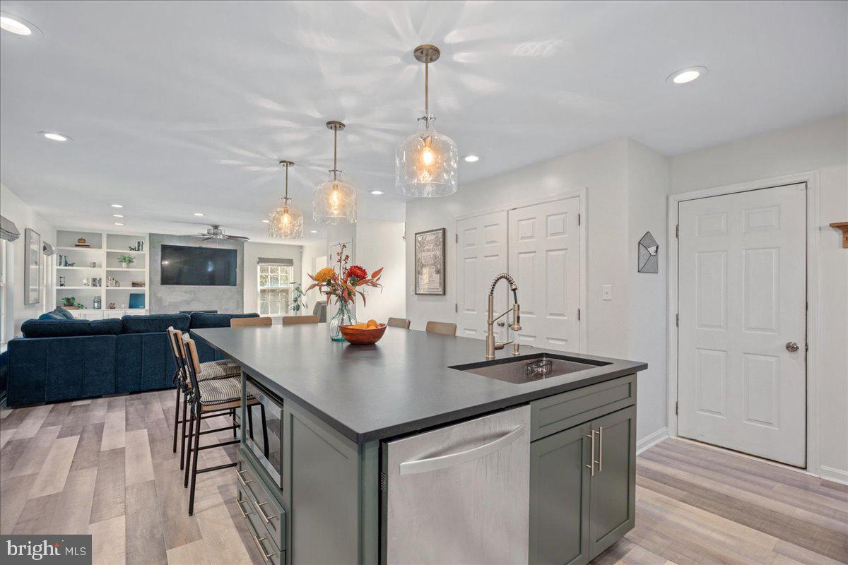 1755 Lottie Fowler Road Prince Frederick, MD 20678 - Photo 27 of 76 a kitchen with stainless steel appliances granite countertop a sink counter space and wooden floor