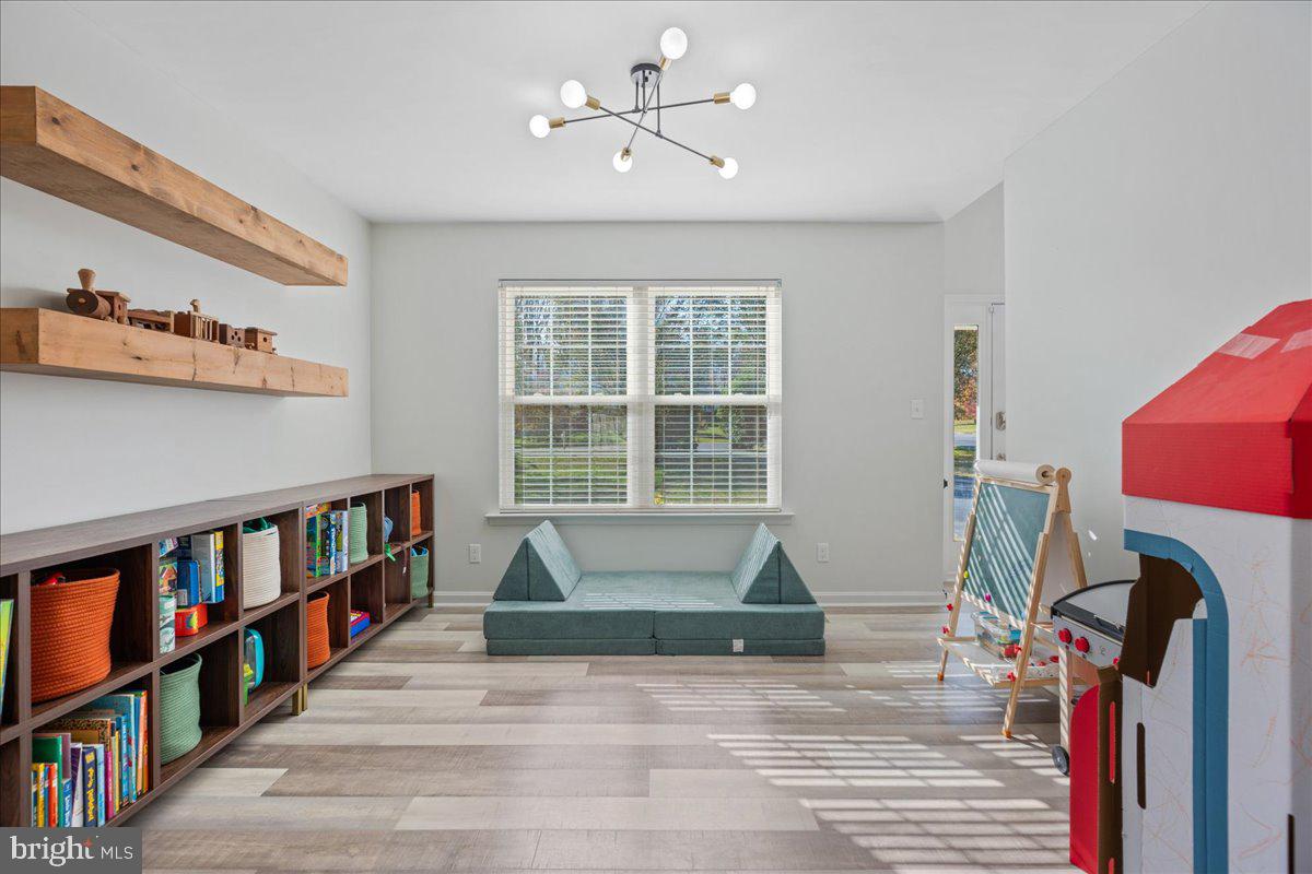 1755 Lottie Fowler Road Prince Frederick, MD 20678 - Photo 36 of 76 a living room with lots of furniture and a book shelf