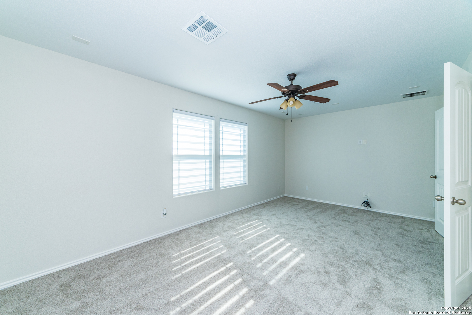 7735 Brisbane Bend Converse, TX 78109 - Photo 12 of 15 an empty room with a ceiling fan and window