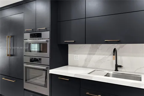 a kitchen with a sink and stainless steel appliances