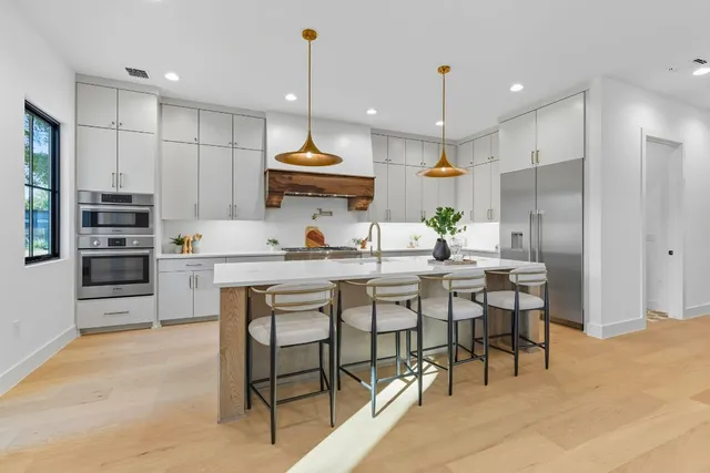 a kitchen with kitchen island granite countertop a sink a center island stainless steel appliances and cabinets