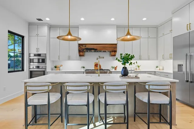 a kitchen with kitchen island granite countertop a sink and white cabinets