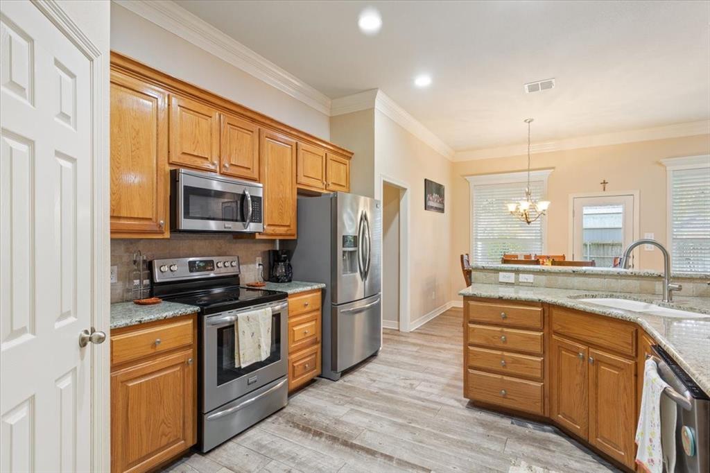5620 Landsdown Drive Waco, TX 76708 - Photo 12 of 37 a kitchen with stainless steel appliances granite countertop a stove top oven a sink dishwasher a refrigerator and cabinets with wooden floor