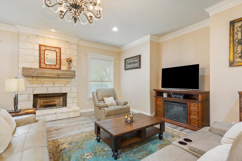 5620 Landsdown Drive Waco, TX 76708 - Photo 9 of 37 a living room with furniture a flat screen tv and a fireplace
