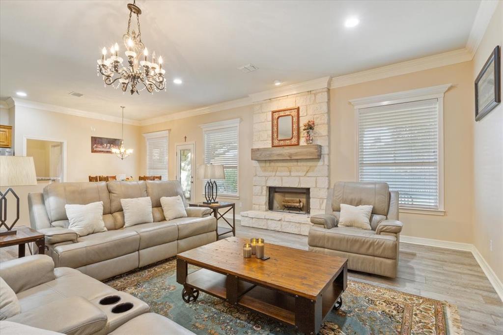 5620 Landsdown Drive Waco, TX 76708 - Photo 10 of 37 a living room with furniture a chandelier and a fireplace