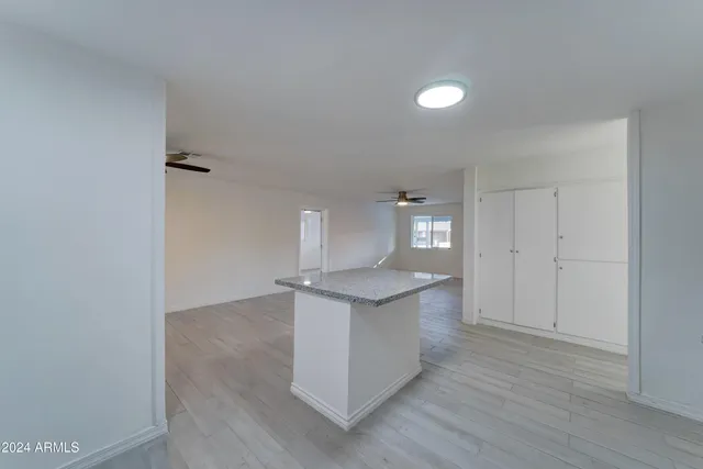 a kitchen with granite countertop white cabinets and white appliances