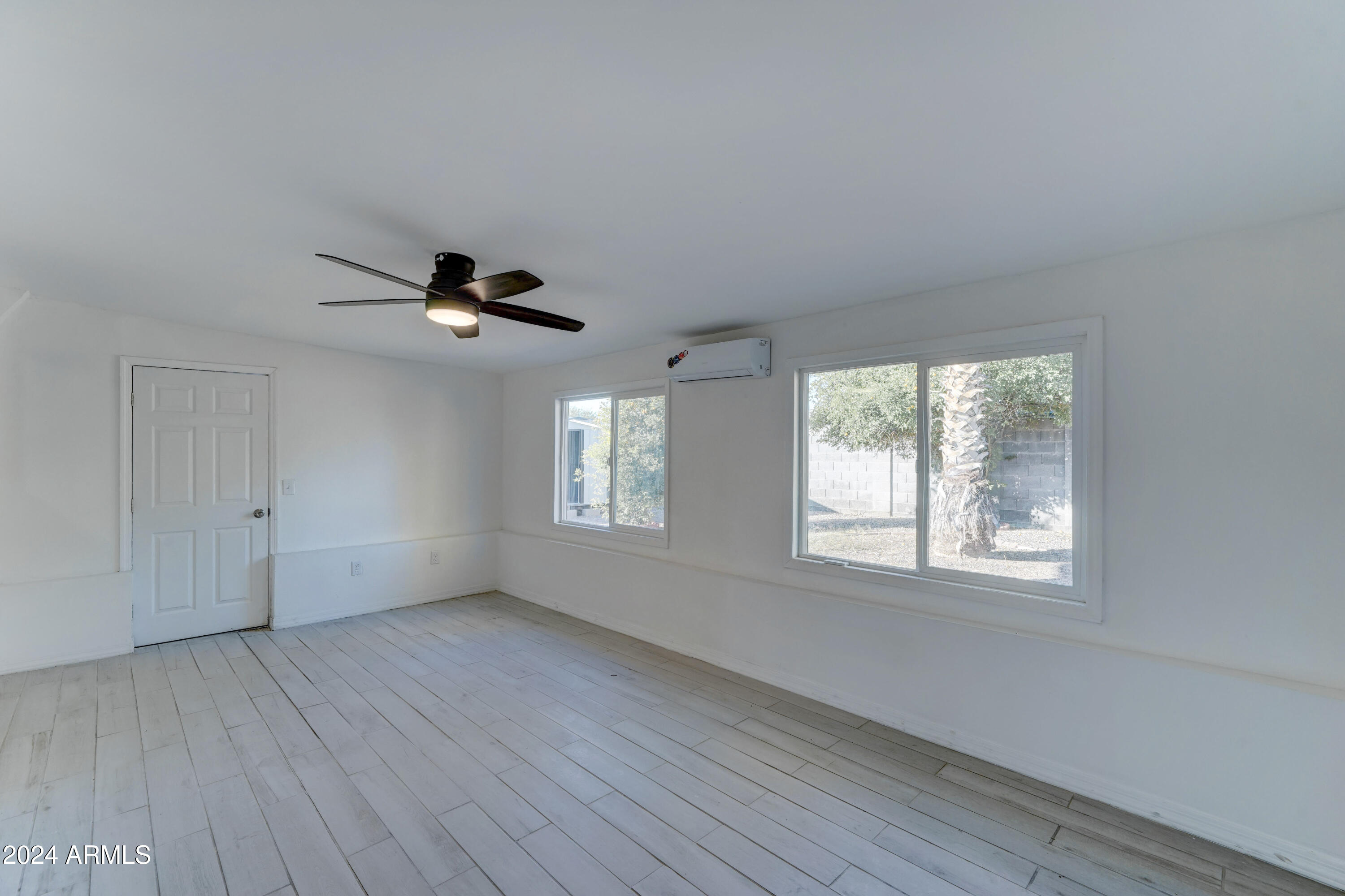 4522 North 14th Avenue Phoenix, AZ 85013 - Photo 13 of 36 a view of an empty room with a window and wooden floor