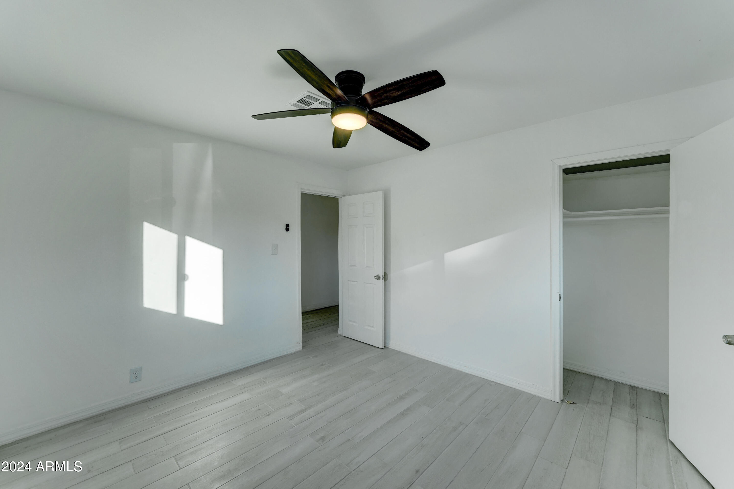 4522 North 14th Avenue Phoenix, AZ 85013 - Photo 21 of 36 a view of empty room with wooden floor and ceiling fan