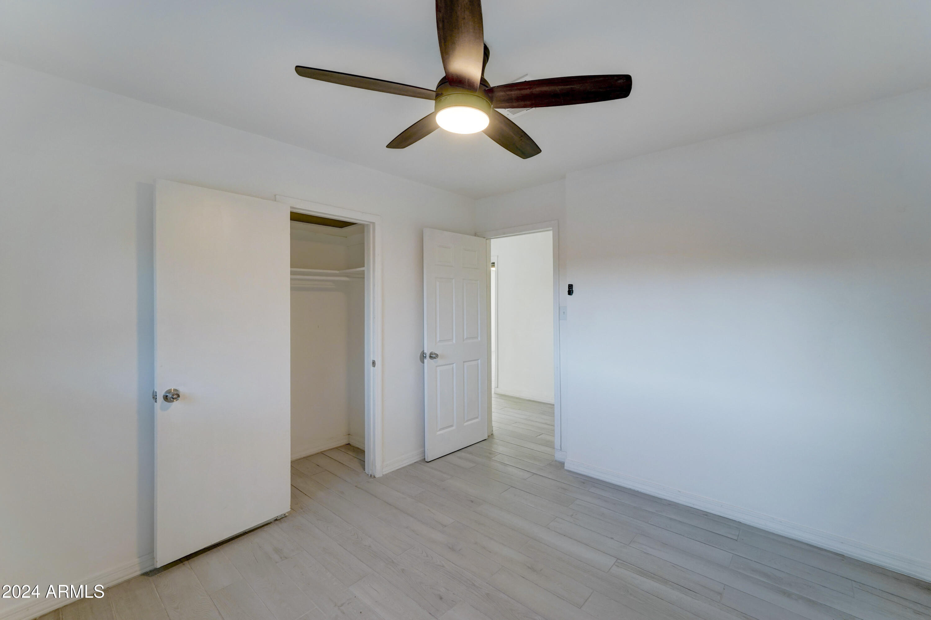 4522 North 14th Avenue Phoenix, AZ 85013 - Photo 23 of 36 an empty room with wooden floor ceiling fan and window