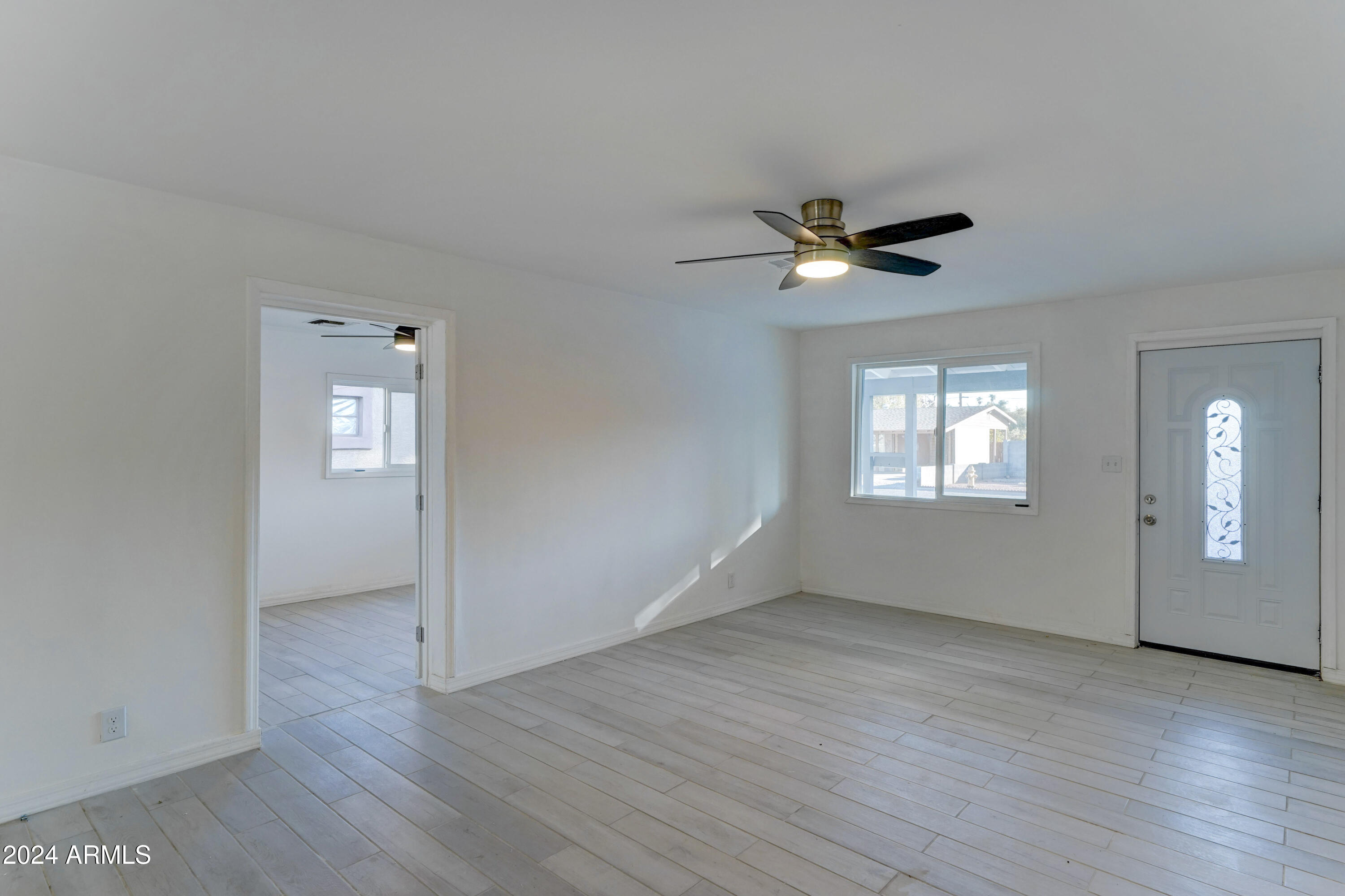 4522 North 14th Avenue Phoenix, AZ 85013 - Photo 5 of 36 an empty room with wooden floor and a ceiling fan