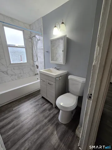 a bathroom with a granite countertop toilet a sink and a bathtub
