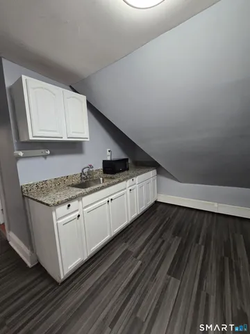 a kitchen with granite countertop a sink and a stove top oven