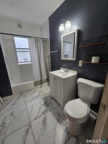 a bathroom with a sink a toilet a mirror and vanity