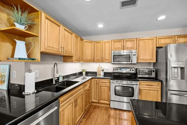 a kitchen with stainless steel appliances a sink cabinets and a window