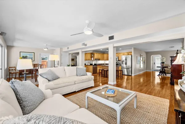 a living room with furniture and a table with wooden floor