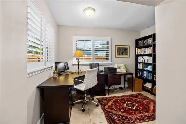 a view of a workspace with furniture and a bookshelf