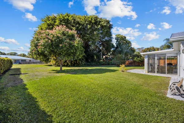 a view of a fountain in front of a house with a yard