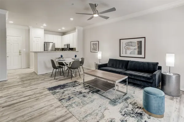 a living room with furniture a view of dining room and wooden floor