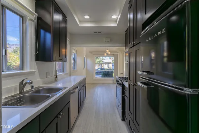 a kitchen with stainless steel appliances a sink and cabinets
